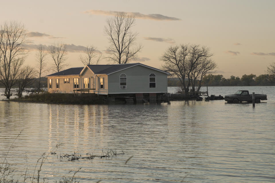 In this Tuesday, Oct. 22, 2019 photo, a home is surrounded by floodwaters in Bartlett, Iowa. Flooding along the Missouri River has stretched on for seven months in places and could endure through the winter, leaving some Upper Midwest farmland and possibly some homes encased in ice. (AP Photo/Nati Harnik)