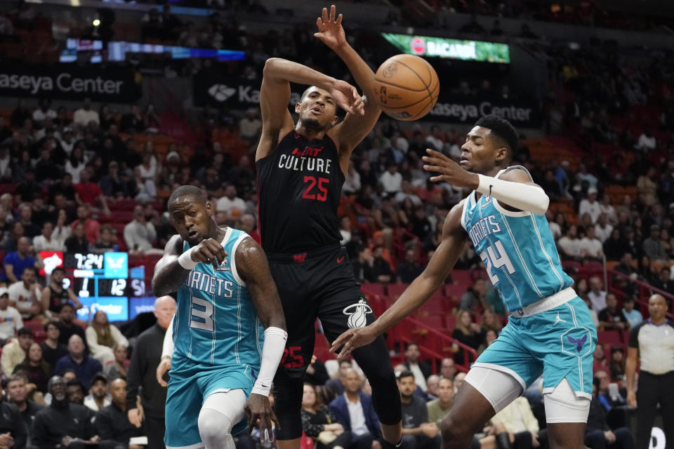 Miami Heat center Orlando Robinson (25) loses control of the ball as Charlotte Hornets guard Terry Rozier (3) and forward Brandon Miller (24) defend during the first half of an NBA basketball game, Wednesday, Dec. 13, 2023, in Miami. (AP Photo/Lynne Sladky)