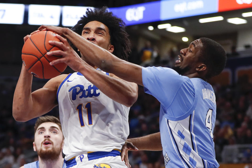 Pittsburgh's Justin Champagnie (11) shoots as North Carolina's Brandon Robinson (4) defends during the first half of an NCAA college basketball game, Saturday, Jan. 18, 2020, in Pittsburgh. (AP Photo/Keith Srakocic)