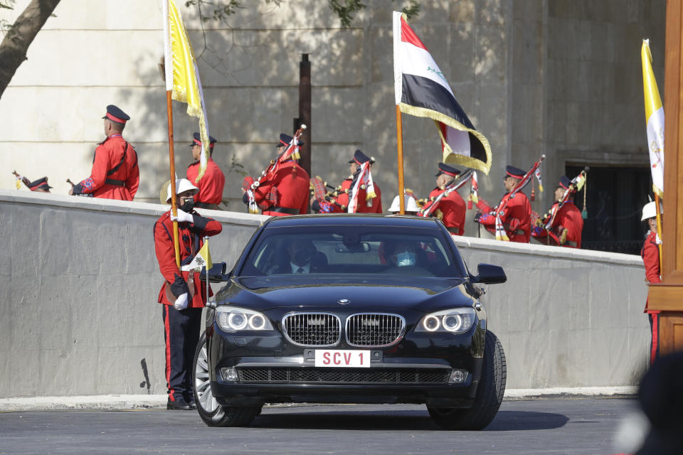 Pope Francis arrives at the Presidential Palace on an armored car, in Baghdad, Iraq, Friday, March 5, 2021. Pope Francis has arrived in Iraq to urge the country's dwindling number of Christians to stay put and help rebuild the country after years of war and persecution, brushing aside the coronavirus pandemic and security concerns. (AP Photo/Andrew Medichini)