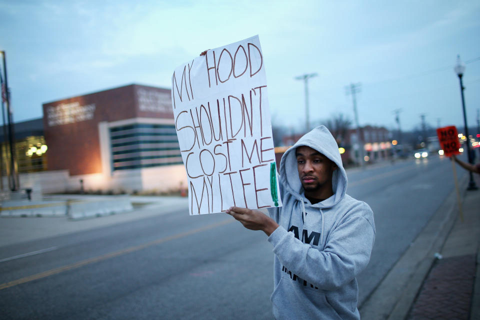 A demonstrator protests in front of the police station on March 12, 2015 in Ferguson, Missouri. Two police officers were shot yesterday while standing outside the station observing a similar protest. Ferguson has faced many violent protests since the August shooting death of Michael Brown by a Ferguson police officer.