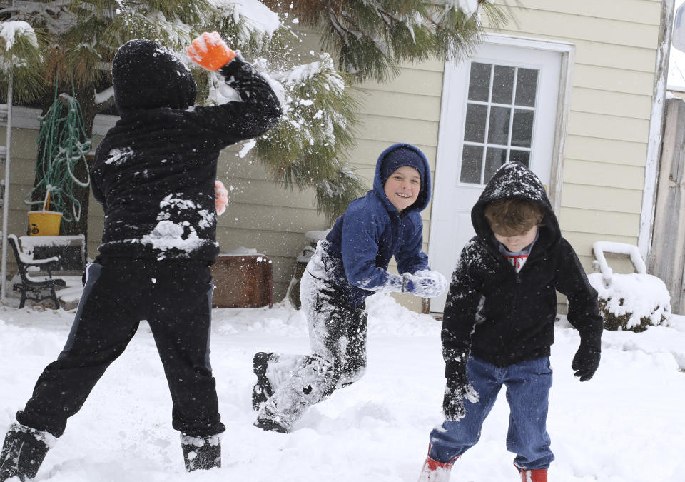 Tuesday's snow called for a snowball fight for the three McKean boys as David, takes aim at his older brother, Ethan Tuesday, Nov. 26, 2019. Younger brother Josiah (5) tried to stay out of the line of fire as the battle raged around him at their home in Scottsbluff, Neb. (Brad Staman/The Star-Herald via AP)