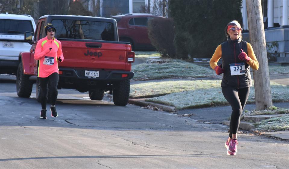 Amanda Mazza (323) leads Leah Wessinger (358) to the finish line as the first two females to complete Little Falls' fifth annual Turkey Trot.