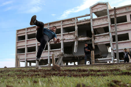 Ibrahim Eid, 16, demonstrates his Parkour skills in front of damaged building in the rebel-held city of Inkhil, west of Deraa, Syria, February 4, 2017. REUTERS/Alaa Al-Faqir