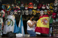 Clerk Wendy Ramirez uses a Spanish flag to wrap souvenirs while preparing to close the store for the day on Olvera Street in Los Angeles, Tuesday, June 8, 2021. Olvera Street has long been a thriving tourist destination and a symbol of the state's early ties to Mexico. The location of where settlers established a farming community in 1781 as El Pueblo de Los Angeles, its historic buildings were restored and rebuilt as a traditional Mexican marketplace in 1930s. As Latinos in California have experienced disproportionately worse outcomes from COVID-19, so too has Olvera Street. (AP Photo/Jae C. Hong)