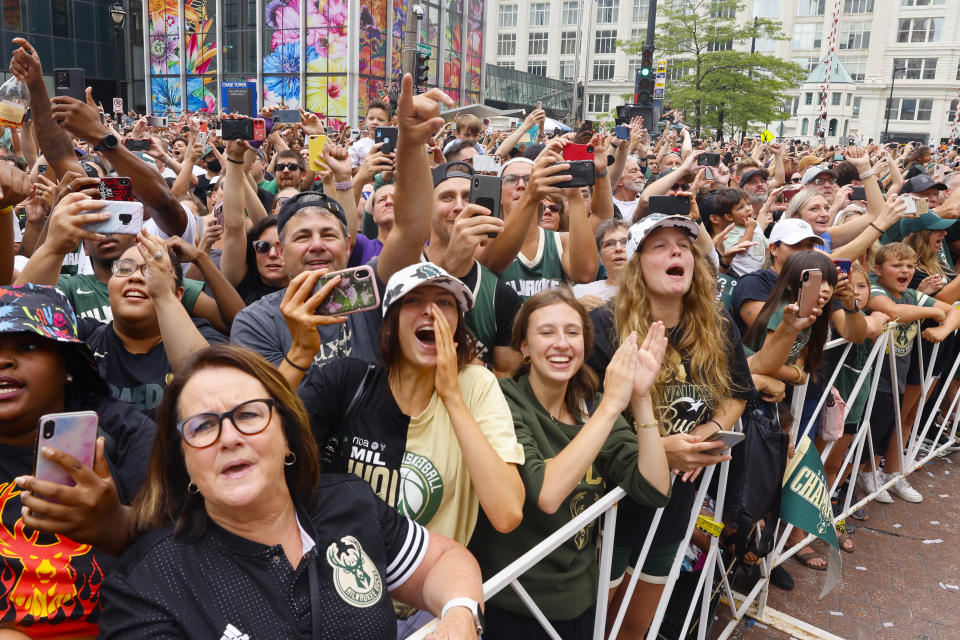 Fans scream for players on buses during a parade and celebration for the NBA Championship Bucks basketball team Thursday, July 22, 2021, in Milwaukee. (AP Photo/Jeffrey Phelps)