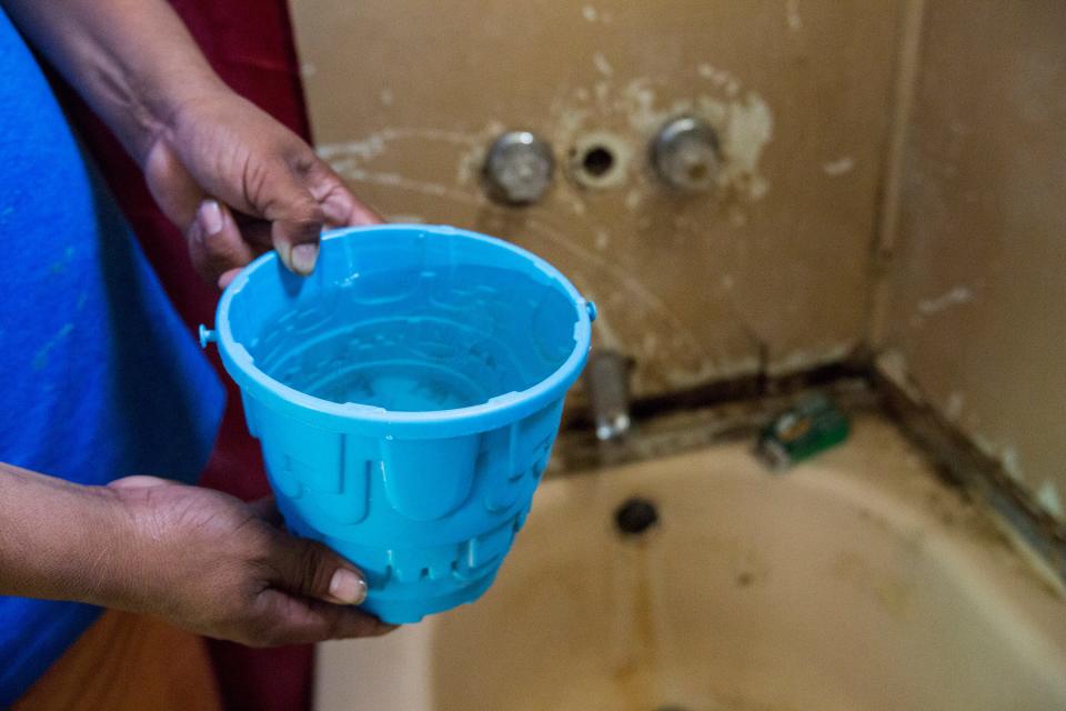 A resident of Oasis Mobile Home Park opens his shower faucet to gather water for cooking. The park was cited by the Environmental Protection Agency for having dangerous levels of arsenic. 