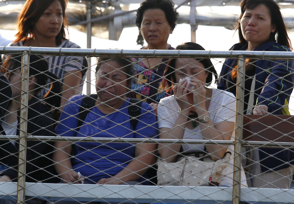 Relatives of the victims cry Tuesday, Oct. 2, 2012 as they pay tribute to the ill-fated people aboard a boat that sank Monday night near Lamma Island, off the southwestern coast of Hong Kong Island. The boat packed with revelers on a long holiday weekend collided with a ferry and sank off Hong Kong, killing at least 36 people and injuring dozens, authorities said. (AP Photo/Vincent Yu)