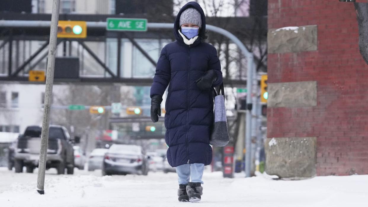 A woman bundled up in winter wear walks through Calgary's downtown on Jan. 10. (Monty Kruger/CBC - image credit)