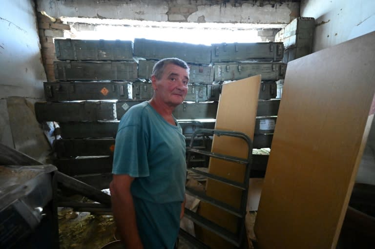 Oleksandre Kokovitch devant un trou dans le mur de sa maison, bouché avec des caisses d'obus russes, le 8 août 2023 dans le village de Mala Komychouvakha, dans le nord-est de l'Ukraine (SERGEY BOBOK)