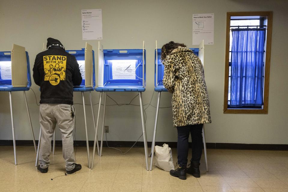 Mayoral candidate Sheila Nezhad, right, casts her vote on Election Day at the Gichitwaa Kateri Catholic Church on Tuesday, Nov. 2, 2021 in Minneapolis. Voters in Minneapolis are deciding whether to replace the city's police department with a new Department of Public Safety. The election comes more than a year after George Floyd's death launched a movement to defund or abolish police across the country.(AP Photo/Christian Monterrosa)