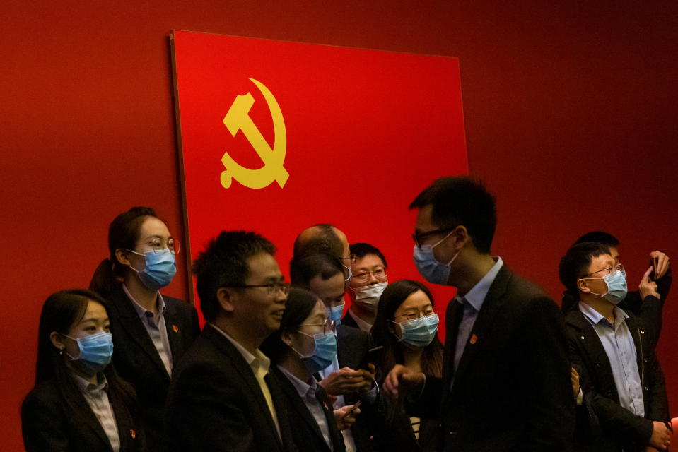 People stand in front of the Chinese national flag at an exhibition marking the 100th founding anniversary of the Chinese Communist Party (CCP) in Beijing, China, April 22, 2021.  REUTERS/Thomas Peter