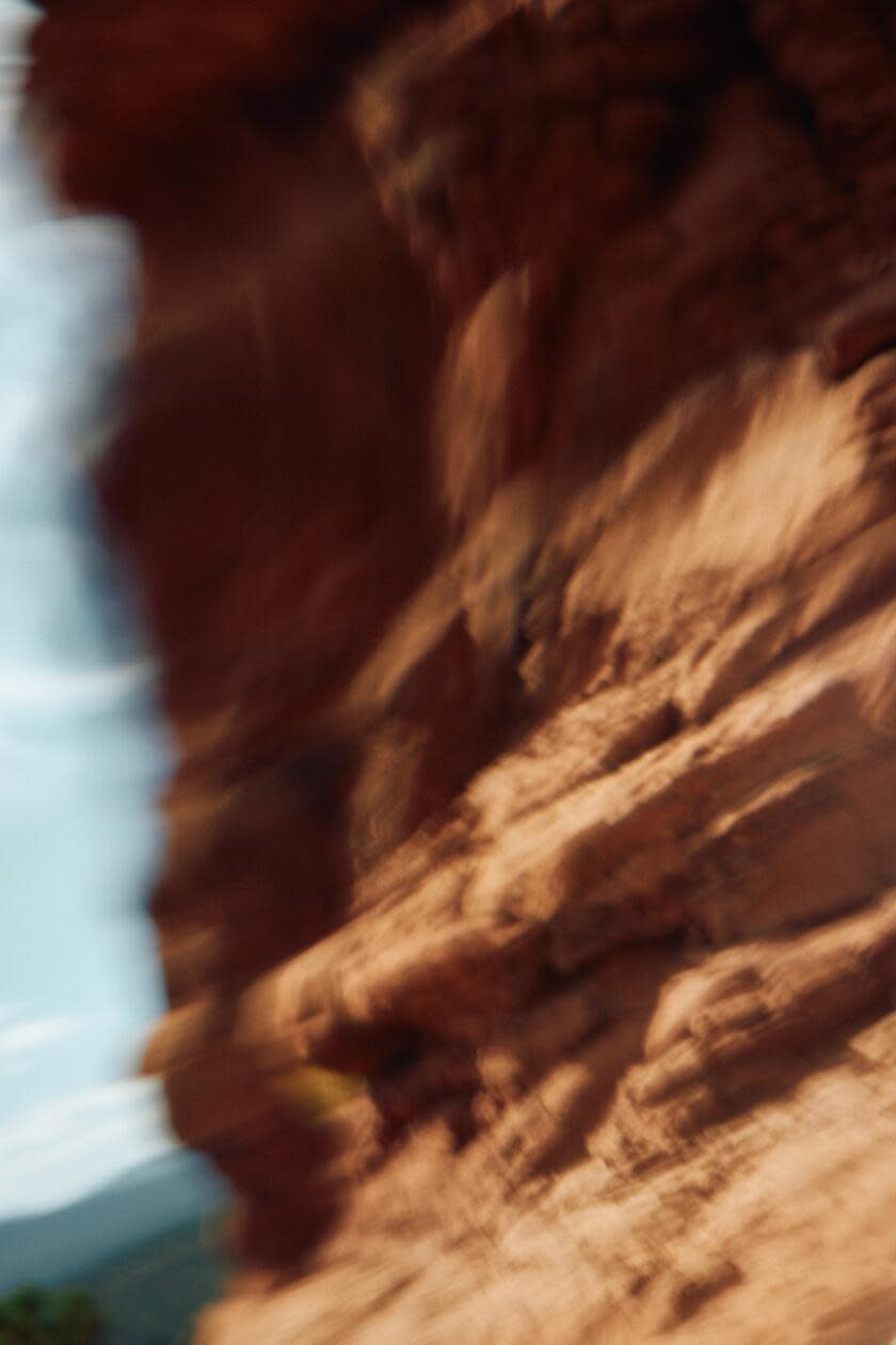 The edges of towering red rock are fuzzy in a stylized photo. 
