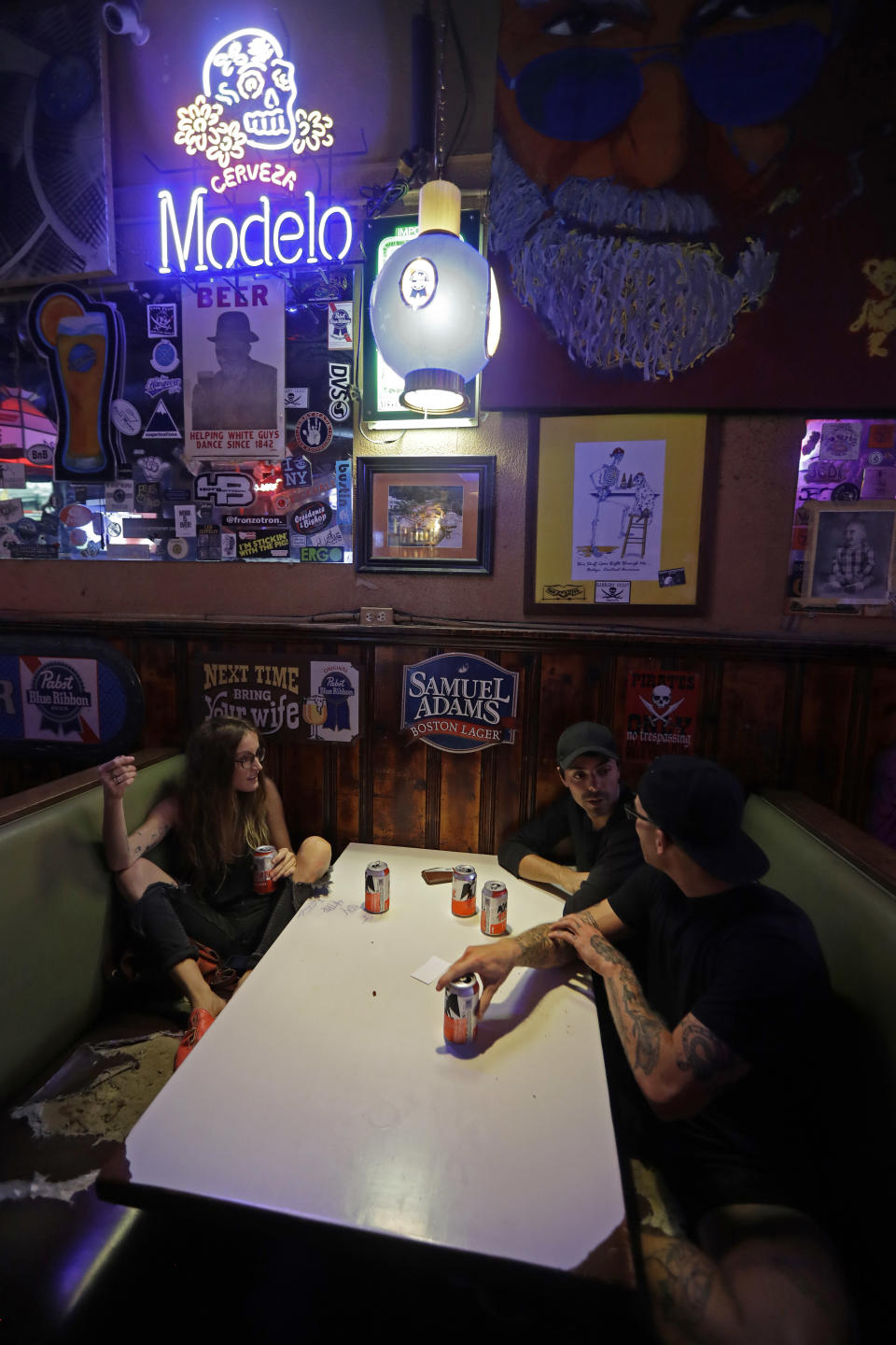 Kathryn Cloniger-Kirk, left, Michael Ussery, right, and Steven Harrington, back, chat as they relax at Barbary Coast bar in downtown Wilmington, N.C., as the Florence threatens the coast Thursday, Sept. 13, 2018. (AP Photo/Chuck Burton)