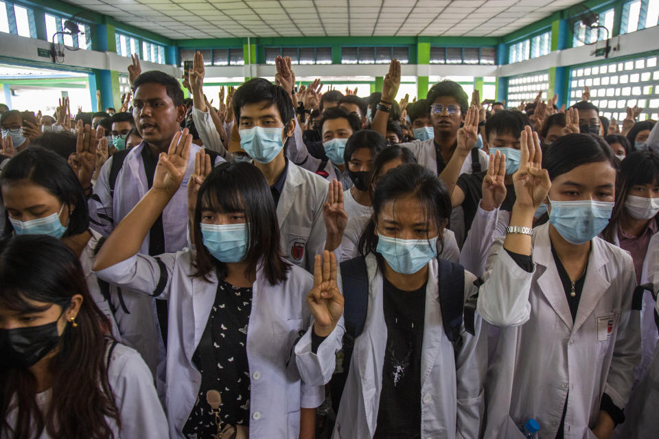 Fellow medical students flash three-fingered salute during the funeral of Khant Ngar Hein in Yangon, Myanmar Tuesday, March 16, 2021. Khant Ngar Hein, a 18-year old student of medicine was shot on his chest on Sunday, March 14, in Tamwe, Yangon by security forces during an anti-crop protest. Demonstrators in several areas of Myanmar protesting last month’s seizure of power by the military held small, peaceful marches before dawn Tuesday, avoiding confrontations with security forces who have shot dead scores of their countrymen in the past few days.(AP Photo)