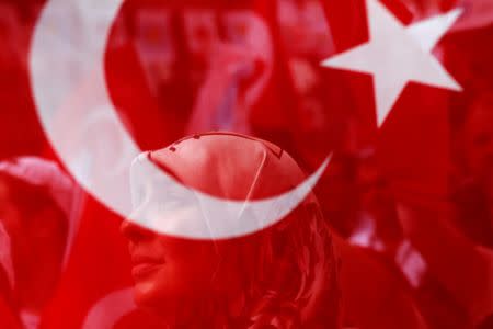 A supporter of Iyi (Good) Party is seen through a Turkish flag during an election rally in Istanbul, Turkey, June 21, 2018. REUTERS/Alkis Konstantinidis