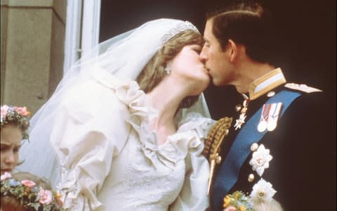 Charles, Prince of Wales, kisses his bride, Lady Diana, on the balcony of Buckingham Palace when they appeared before a huge crowd, on July 29, 1981 - Credit: AFP