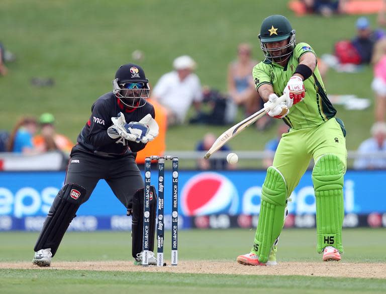 Pakistan's Ahmed Shehzad (R) plays a shot as UAE's Swapnil Patil looks on during their Cricket World Cup match in Napier on March 4, 2015