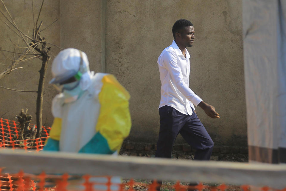 In this Saturday, July 20, 2019 photo, Claude Mabowa Sasi, 21, who had lost his mother, a brother and a sister to Ebola, walks in an Ebola treatment center as he recovers from the disease in Beni, Congo. “My mother had told me: ‘My son, you must study. If you have your diploma, you will succeed in life. Even if your parents are gone, you still have your life to live,’” he said. (AP Photo/Al-Hadji Kudra Maliro)