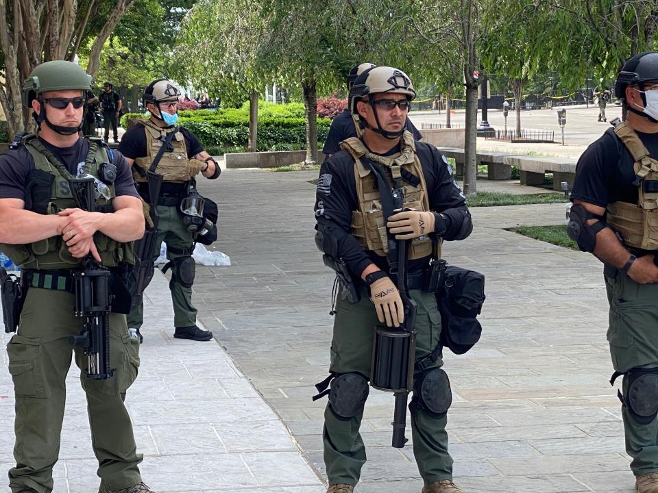 Federal law enforcement officers wear unidentifiable uniforms, some with plain T-shirts under their military-style gear, while they hold a line near the White House on Wednesday. (Photo: Ryan J. Reilly/HuffPost)