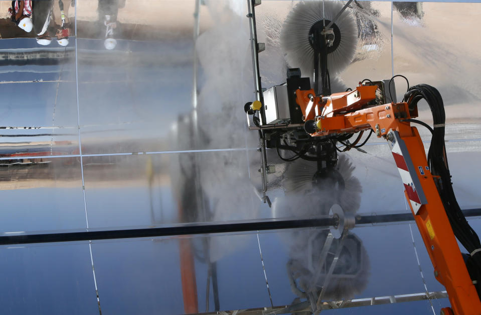 A machine cleans with water a row of parabolic shape mirrors, at the Shams 1, Concentrated Solar power (CSP) plant. (MARWAN NAAMANI/AFP/Getty Images)