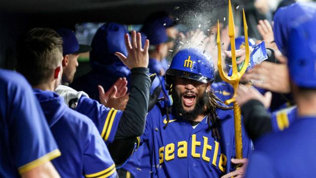 Seattle Mariners' J.P. Crawford (3) carries his gear to the on