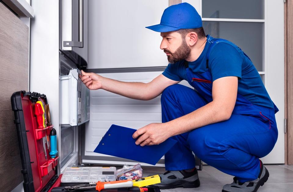 Technician examining a refrigerator