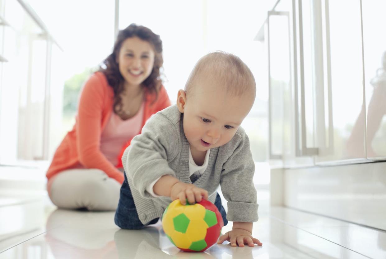 <span class="caption">Experts believe that infants should get some interactive floor-based physical activity two to three times a day.</span> <span class="attribution"><a class="link " href="https://www.gettyimages.com/detail/photo/mother-watching-baby-playing-with-ball-royalty-free-image/135385235?adppopup=true" rel="nofollow noopener" target="_blank" data-ylk="slk:Sam Edwards/OJO Images via Getty Images;elm:context_link;itc:0;sec:content-canvas">Sam Edwards/OJO Images via Getty Images</a></span>