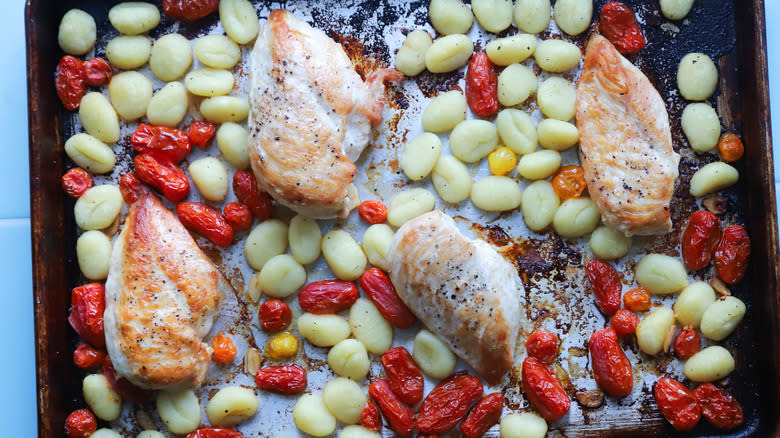 Roasted gnocchis, chicken, and tomatoes on tray
