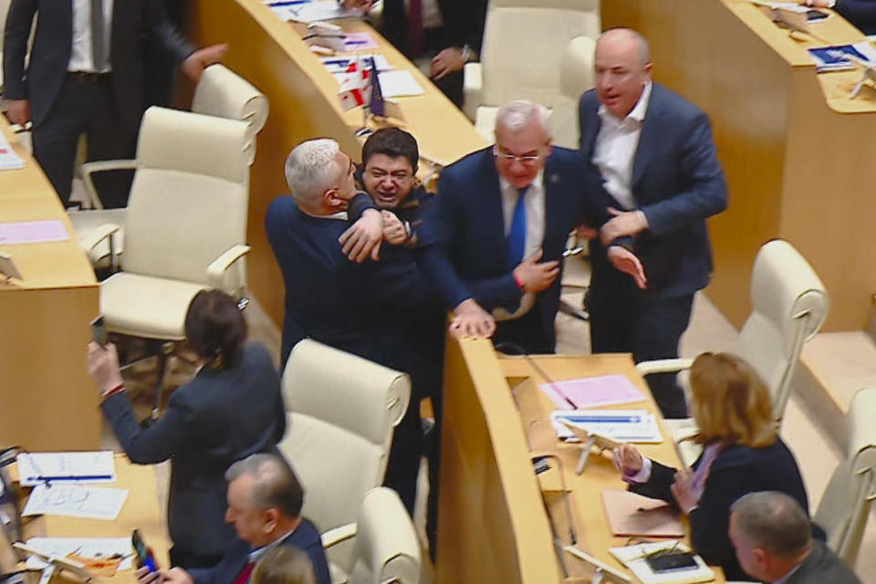 This photo taken from video, released by Mtavari Channel on Tuesday, May 14, 2024, shows Georgian lawmakers fighting during a parliament session in Tbilisi, Georgia. Georgia's parliament on Tuesday began the third and final reading of a divisive bill that sparked weeks of mass protests, with critics seeing it as a threat to democratic freedoms and the country's aspirations to join the European Union. (Mtavari Channel via AP)