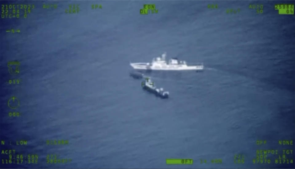 In this image released by the Armed Forces of the Philippines, a Philippines supply boat, center, sails near a Chinese coast guard ship, top, and a Chinese militia vessel off Second Thomas Shoal, locally called Ayungin Shoal, at the disputed South China Sea on Sunday Oct. 22, 2023. (Armed Forces of the Philippines via AP)
