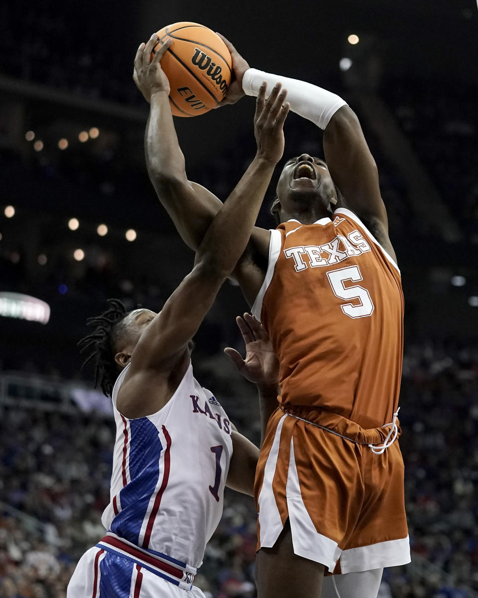 Texas guard Marcus Carr (5) shoots under pressure from Kansas guard Joseph Yesufu (1) during the first half of the NCAA college basketball championship game of the Big 12 Conference tournament Saturday, March 11, 2023, in Kansas City, Mo. (AP Photo/Charlie Riedel)