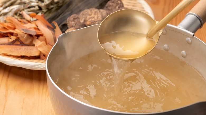 pot of chicken broth with ladle