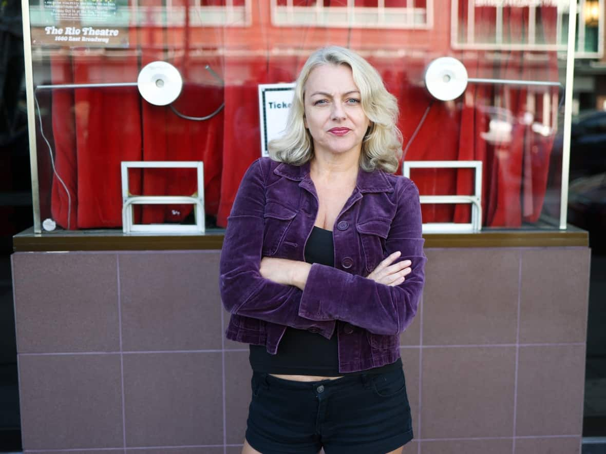 Corinne Lea of Vancouver's Rio Theatre is among the independent cinema owners who say they're the last in line to acquire films — stuck waiting until larger chains, mainly Cineplex Entertainment, are finished with them.  (Andrew Lee/CBC - image credit)