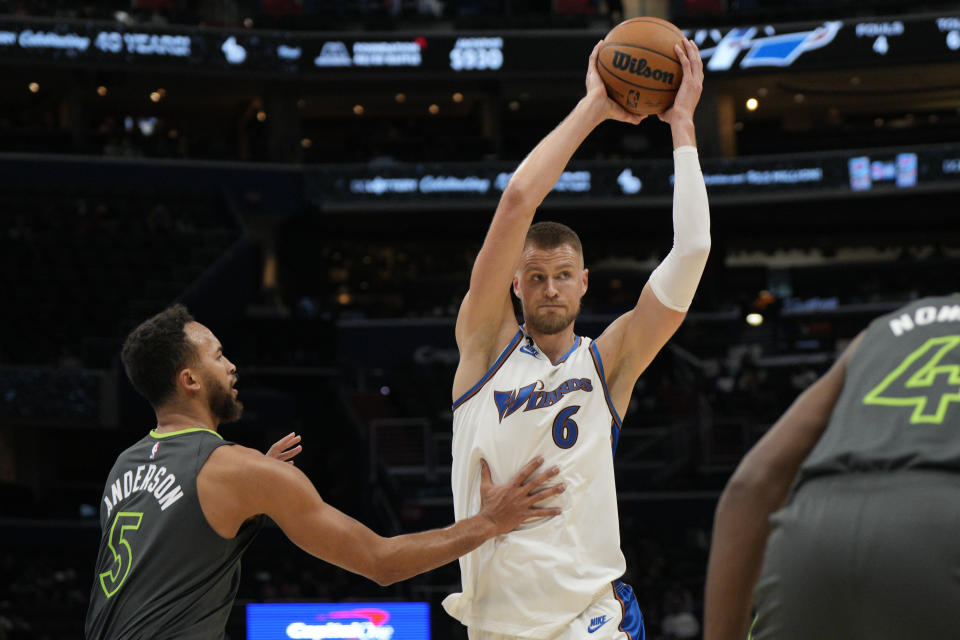 Washington Wizards center Kristaps Porzingis (6) looks to pass against Minnesota Timberwolves forward Kyle Anderson (5) during the first half of an NBA basketball game, Monday, Nov. 28, 2022, in Washington. (AP Photo/Jess Rapfogel)