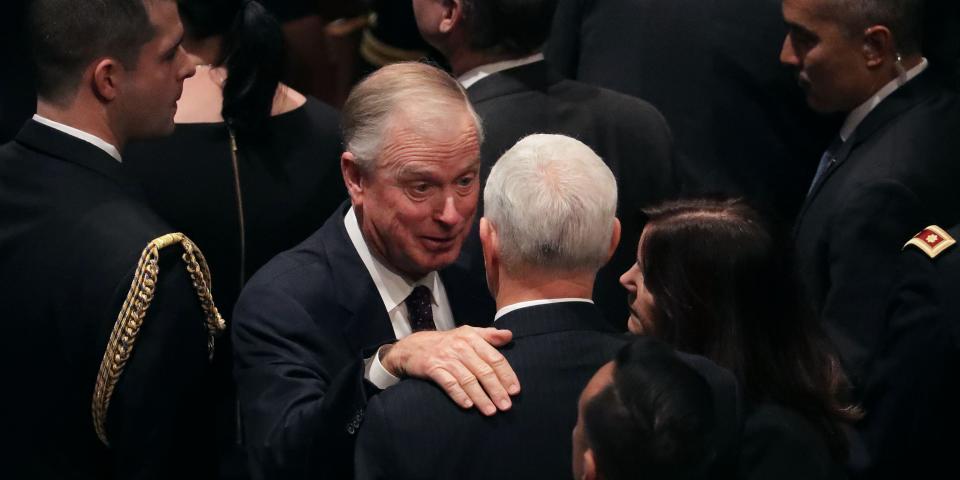 Dan Quayle facing Mike Pence, with his hand on Pence's shoulder.