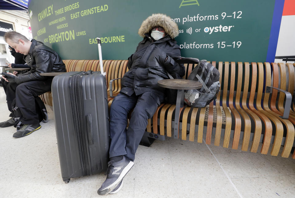 A traveller wears a mask as he waits at Victoria Station in London, Monday, March 16, 2020. For most people, the new coronavirus causes only mild or moderate symptoms, such as fever and cough. For some, especially older adults and people with existing health problems, it can cause more severe illness, including pneumonia. (AP Photo/Kirsty Wigglesworth)