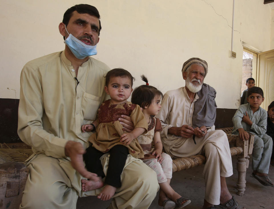 In this May 6, 2020 photo, Tariq Nawaz holds his 10-month-old baby daughter Tuba who suffers from polio, in Suleiman Khel, Pakistan. For millions of people like Nawaz who live in poor and troubled regions of the world, the novel coronavirus is only the latest epidemic. They already face a plethora of fatal and crippling infectious diseases: polio, Ebola, cholera, dengue, tuberculosis and malaria, to name a few. The diseases are made worse by chronic poverty that leads to malnutrition and violence that disrupts vaccination campaigns. (AP Photo/Muhammad Sajjad)