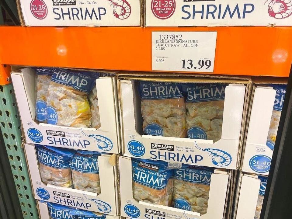 Bags of Kirkland shrimp with a price tag that reads $13.99.