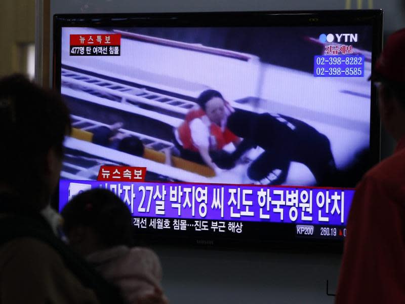 Menschen sehen sich in einer U-Bahnstation in Seoul TV-Bilder der Rettungsaktion an. Foto: Kim Hee-Chul