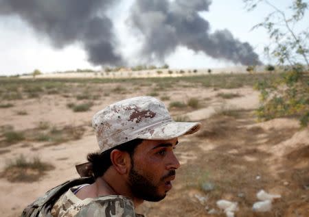 A member of the Libyan forces allied with the U.N.-backed government looks at Islamic State fighters' positions during a battle in Sirte. REUTERS/Goran Tomasevic