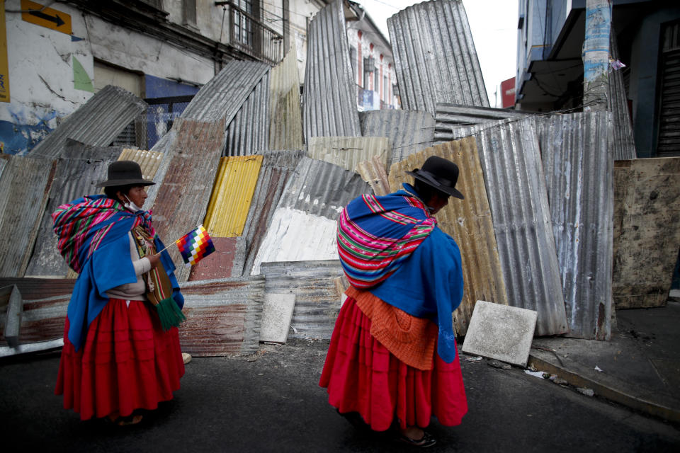 Supporters of former President Evo Morales stand at a barricaded stretch leading to the presidential palace during a march in La Paz, Bolivia, Thursday, Nov. 14, 2019. Morales resigned and flew to Mexico under military pressure following massive nationwide protests over alleged fraud in an election last month in which he claimed to have won a fourth term in office. (AP Photo/Natacha Pisarenko)