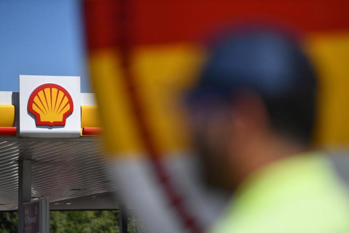 A truck driver stands by the gas container of his truck at a Shell gas station in Berchem in Luxembourg on August 6, 2022 in Berchem. - With world energy prices on the rise, and holidaymakers from northern Europe heading for southern France and the Mediterranean the Shell filling station in Luxembourg -- reputedly the biggest by volume in petrol sales in the world -- is doing strong business with motorists and truckers kee to fill up in the low tax grand duchyt. (Photo by JOHN THYS / AFP) (Photo by JOHN THYS/AFP via Getty Images)