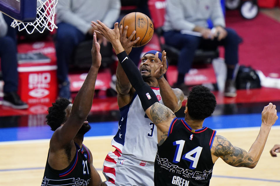 Washington Wizards' Bradley Beal, center, goes up for a shot against Philadelphia 76ers' Danny Green, right, and Joel Embiid during the second half of Game 2 in a first-round NBA basketball playoff series, Wednesday, May 26, 2021, in Philadelphia. (AP Photo/Matt Slocum)