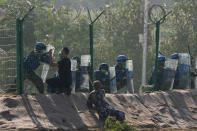 Participants in the role of refugees escaping fighting plead for help outside a United Nations compound during the Shared Destiny 2021 drill at the Queshan Peacekeeping Operation training base in Queshan County in central China's Henan province Wednesday, Sept. 15, 2021. Peacekeeping troops from China, Thailand, Mongolia and Pakistan took part in the 10 days long exercise that field reconnaissance, armed escort, response to terrorist attacks, medical evacuation and epidemic control. (AP Photo/Ng Han Guan)