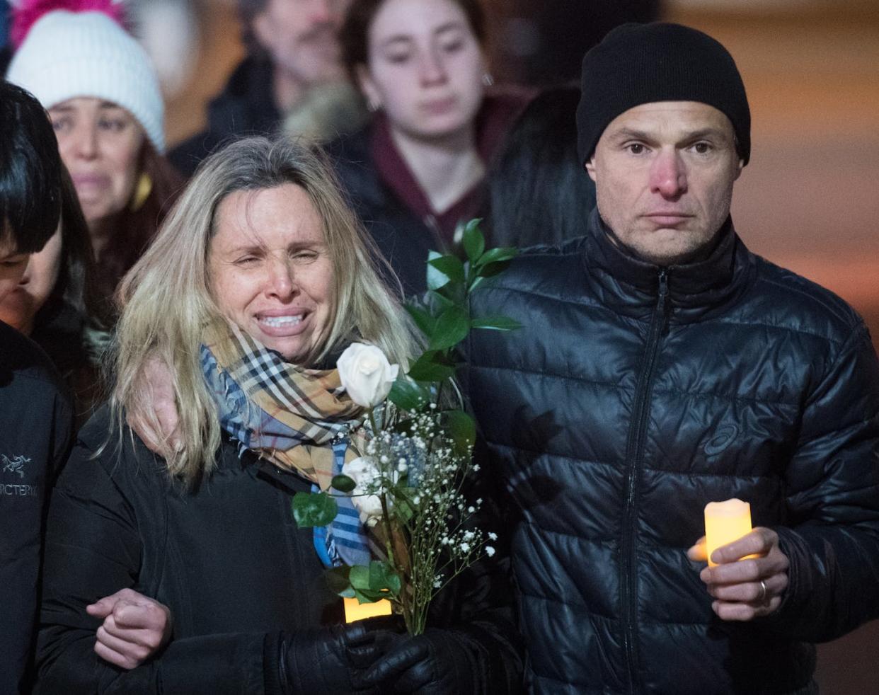 Antonio Magalhaes holds his wife Andrea Magalhaes as they walk towards Keele Station, where their 16-year-old son, Gabriel Magalhaes, was killed in a random attack in the Toronto subway system. THE CANADIAN PRESS/Tijana Martin