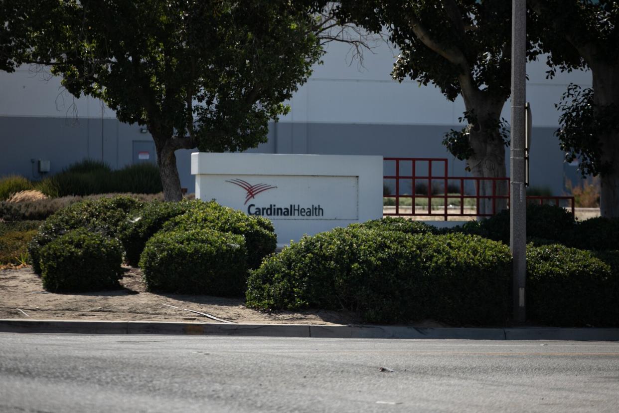 A sign reading Cardinal Health framed by trees