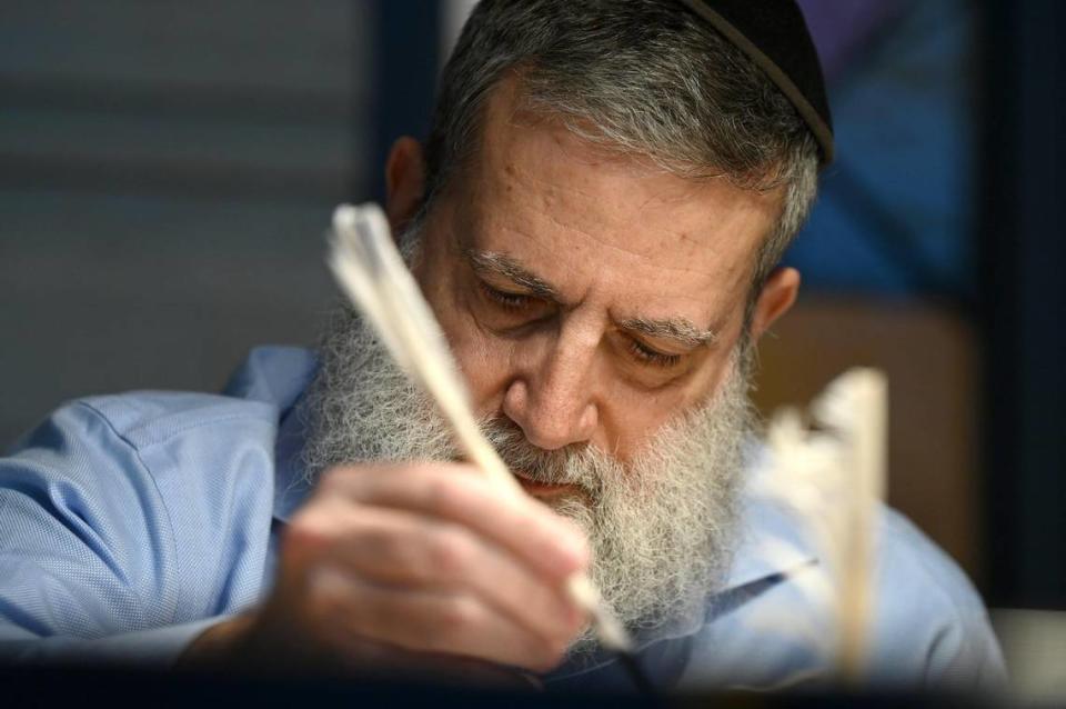 Rabbi Moshe Druin repairs a Torah scroll at Temple Beth El in Charlotte, NC on Tuesday, April 18, 2023. Tuesday is Holocaust Remembrance Day (Yom HaShoah). Druin, a sofer was repairing a Czech Memorial Scroll that survived the Holocaust. The Torah is around 300 years old.