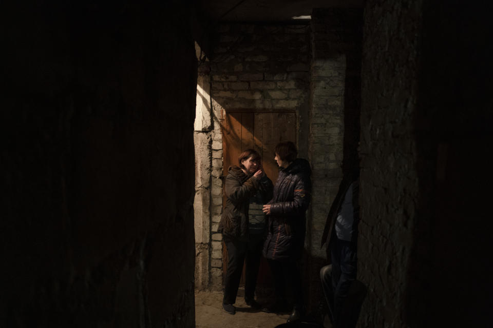 Two women talk as they take shelter inside the basement of a residential building during a Russian attack in Lyman, Ukraine, Tuesday, April 26, 2022. Russia pounded eastern and southern Ukraine on Tuesday as the U.S. promised to "keep moving heaven and earth" to get Kyiv the weapons it needs to repel the new offensive, despite Moscow's warnings that such support could trigger a wider war. (AP Photo/Leo Correa)