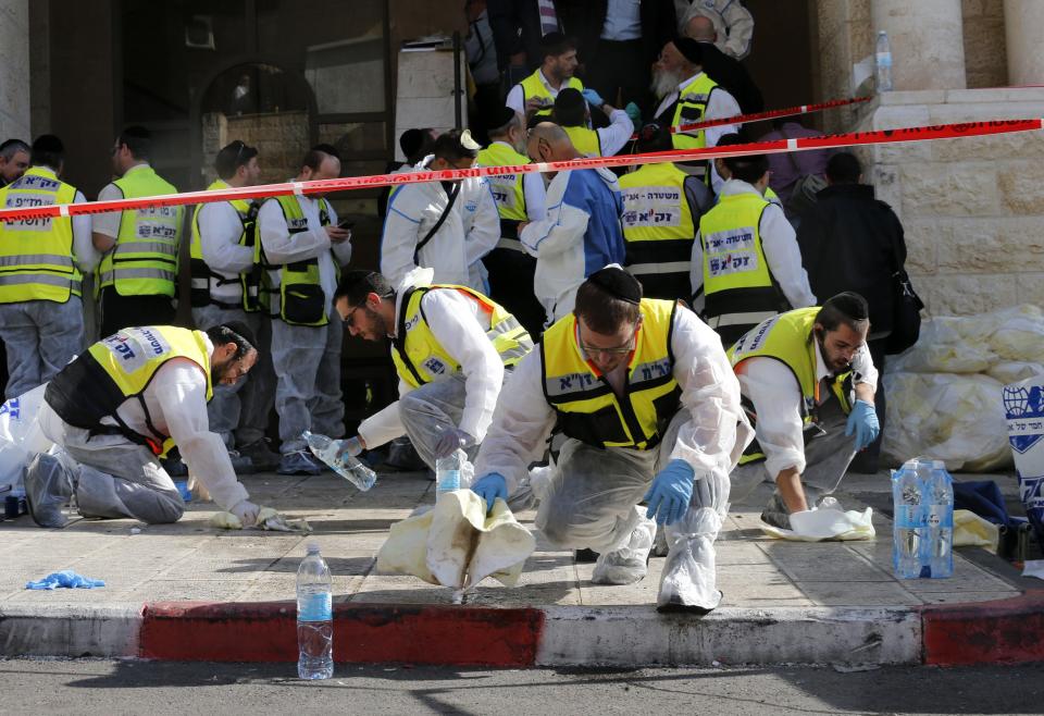 Members of the Israeli Zaka emergency response team clean blood from the scene outside Jerusalem synagogue